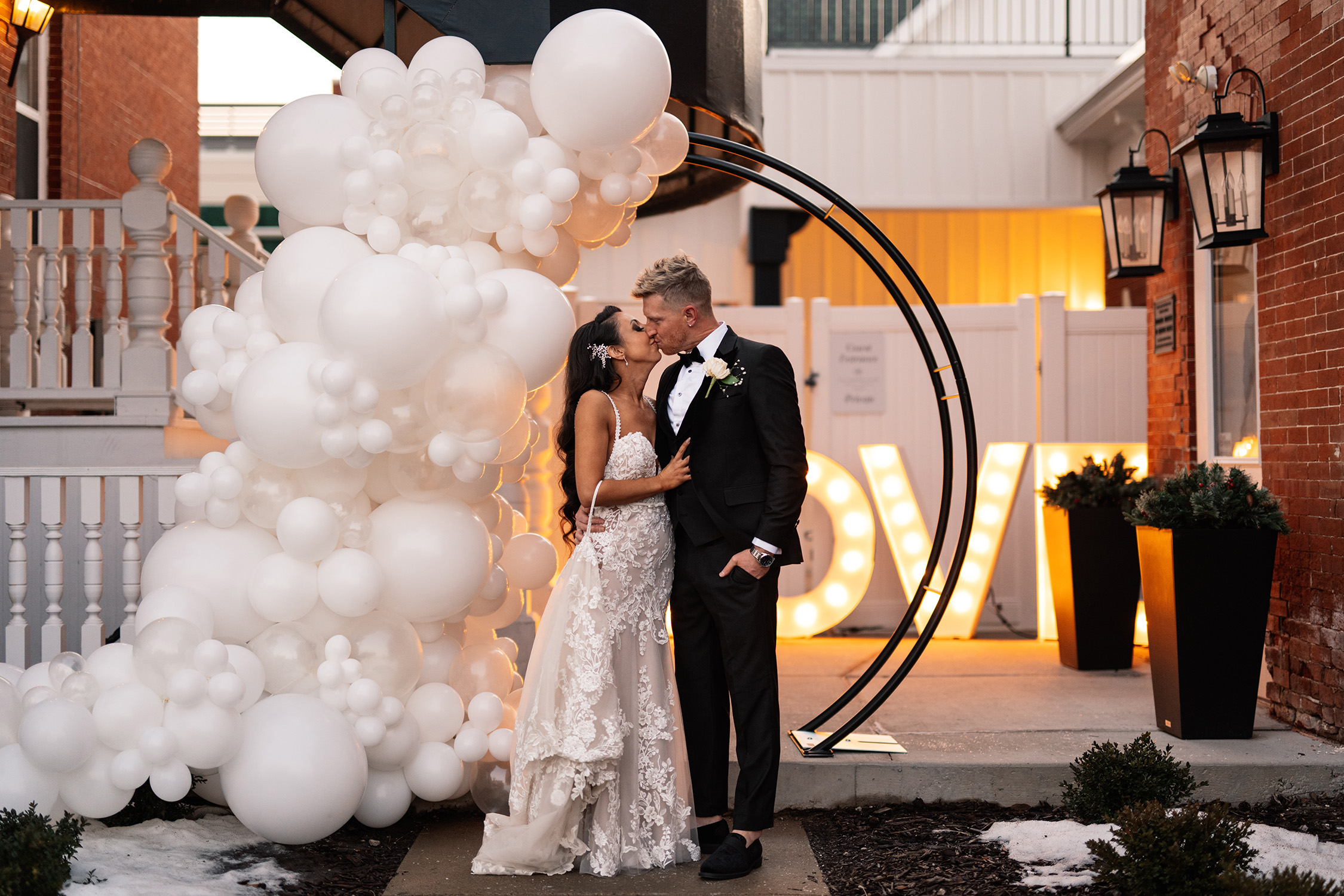 couple under twinkly light wedding arch brick wall olympic south side theater wedding venue cedar rapids