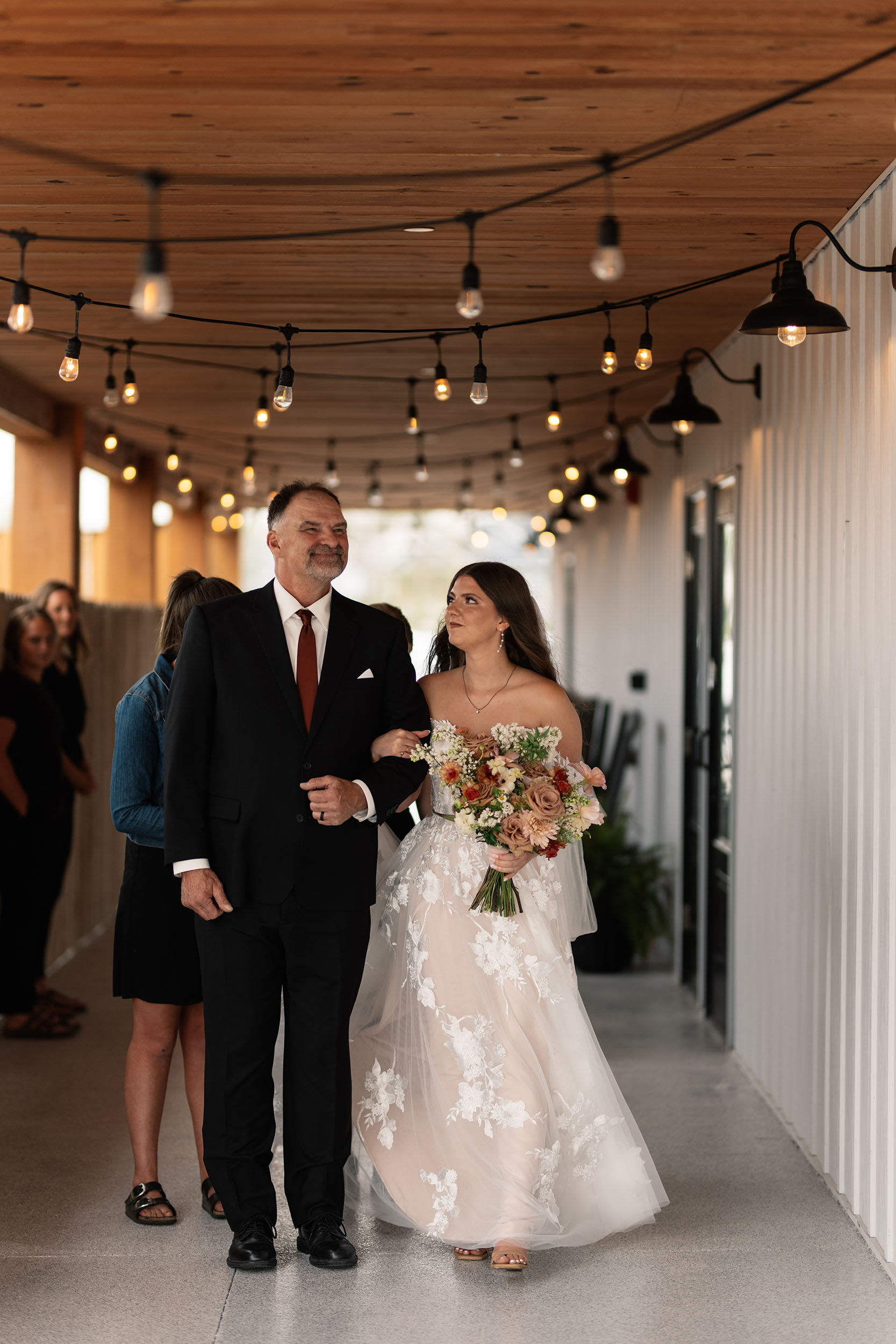 couple under twinkly light wedding arch brick wall olympic south side theater wedding venue cedar rapids