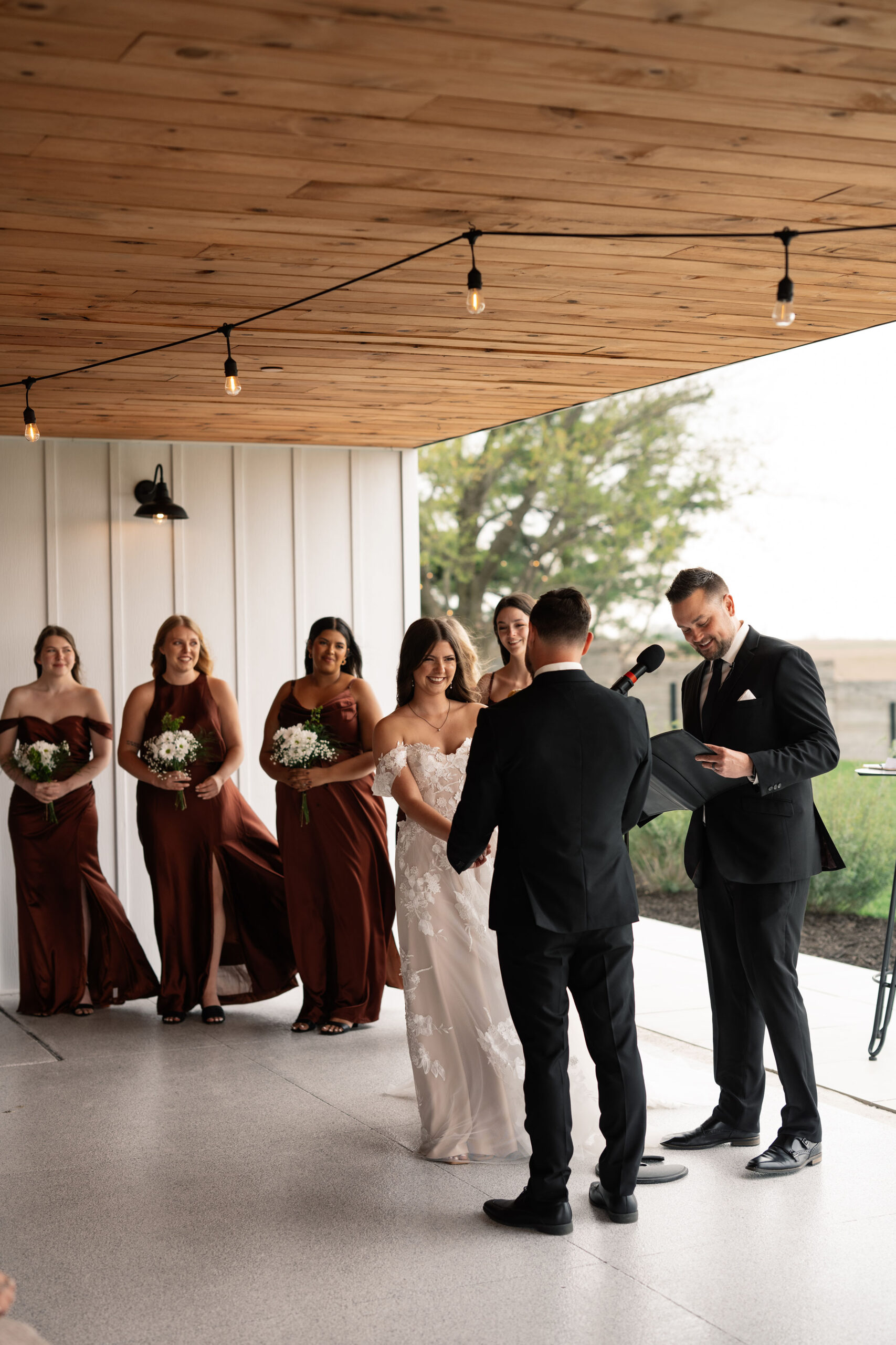 couple under twinkly light wedding arch brick wall olympic south side theater wedding venue cedar rapids