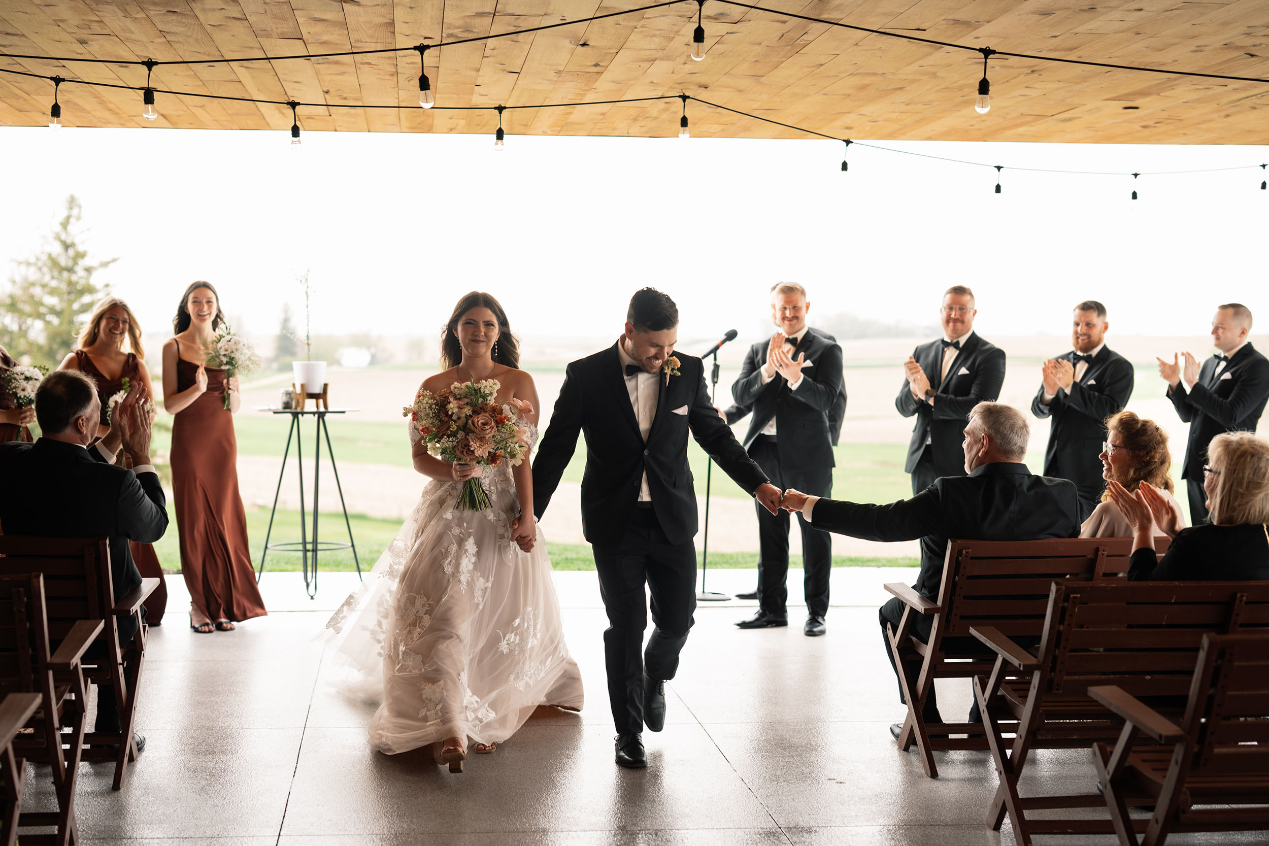 couple under twinkly light wedding arch brick wall olympic south side theater wedding venue cedar rapids