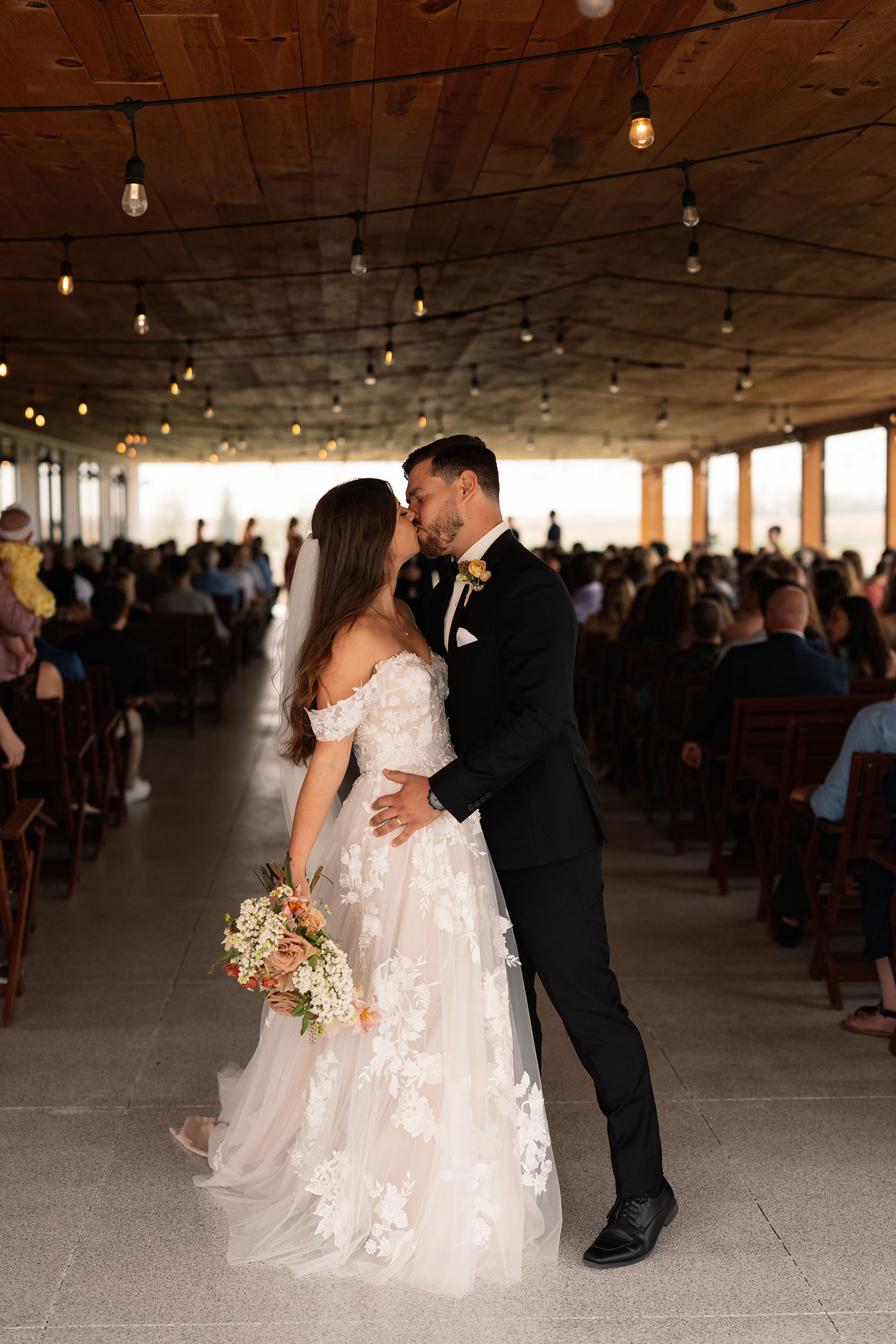 couple under twinkly light wedding arch brick wall olympic south side theater wedding venue cedar rapids