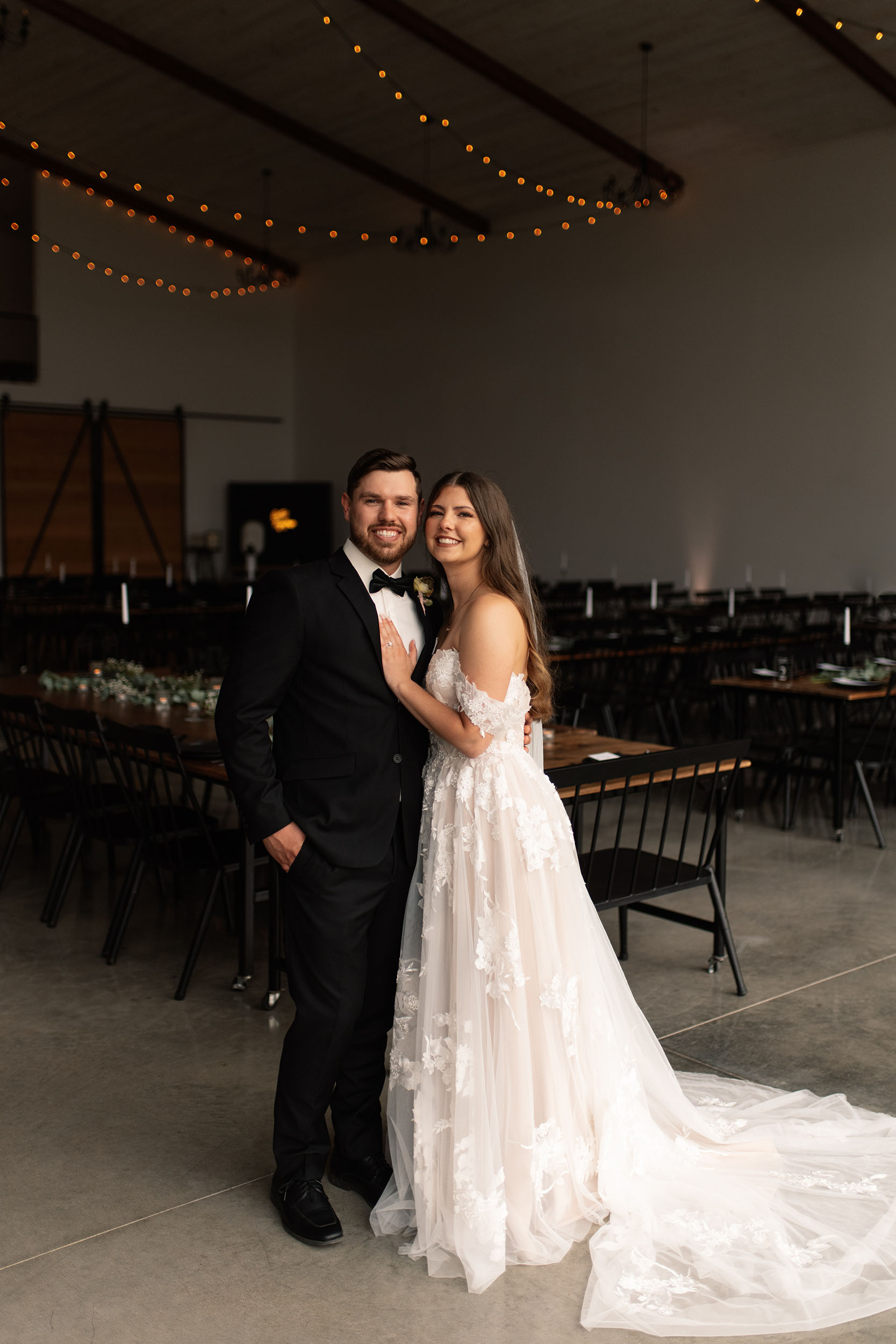 couple under twinkly light wedding arch brick wall olympic south side theater wedding venue cedar rapids