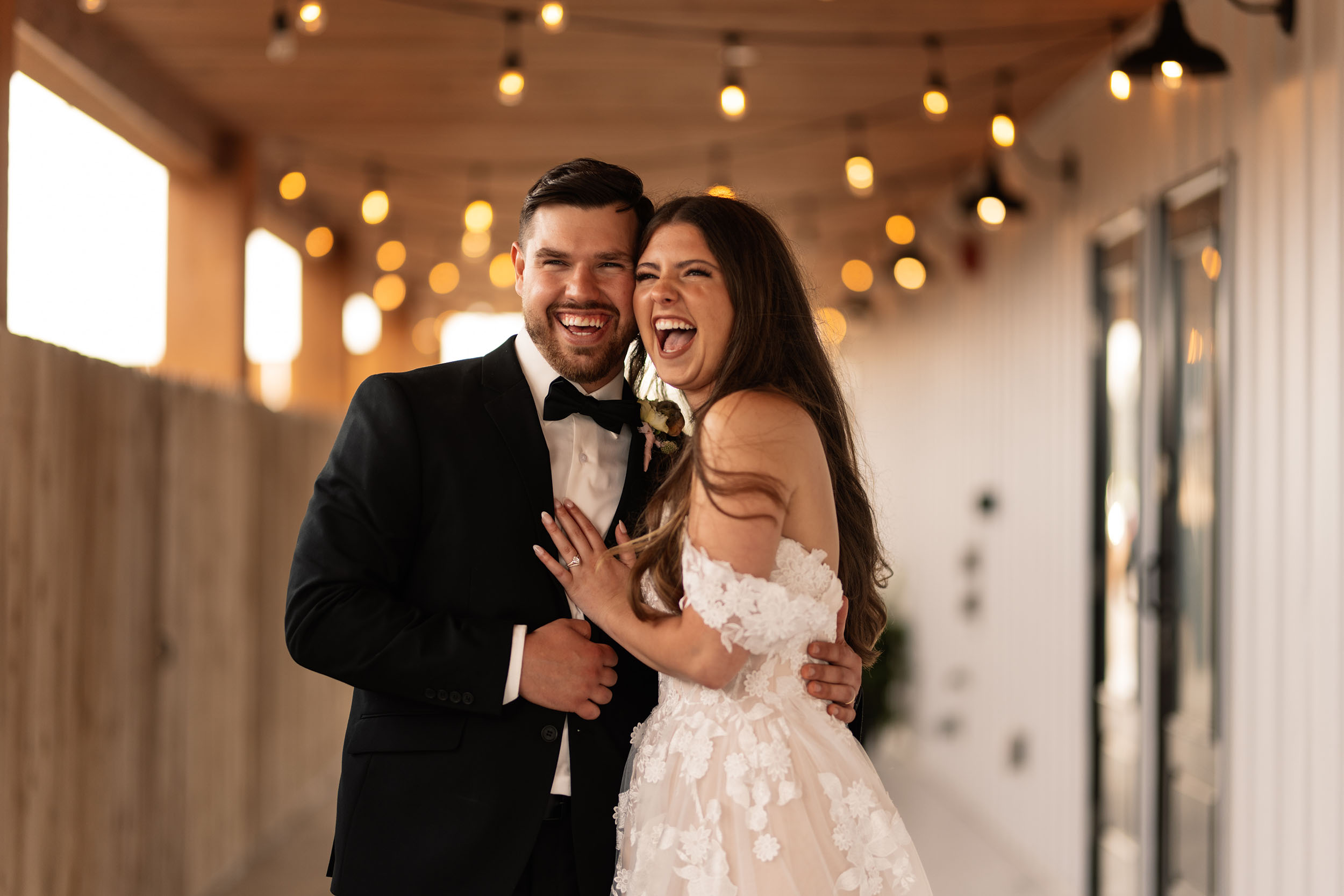 couple under twinkly light wedding arch brick wall olympic south side theater wedding venue cedar rapids