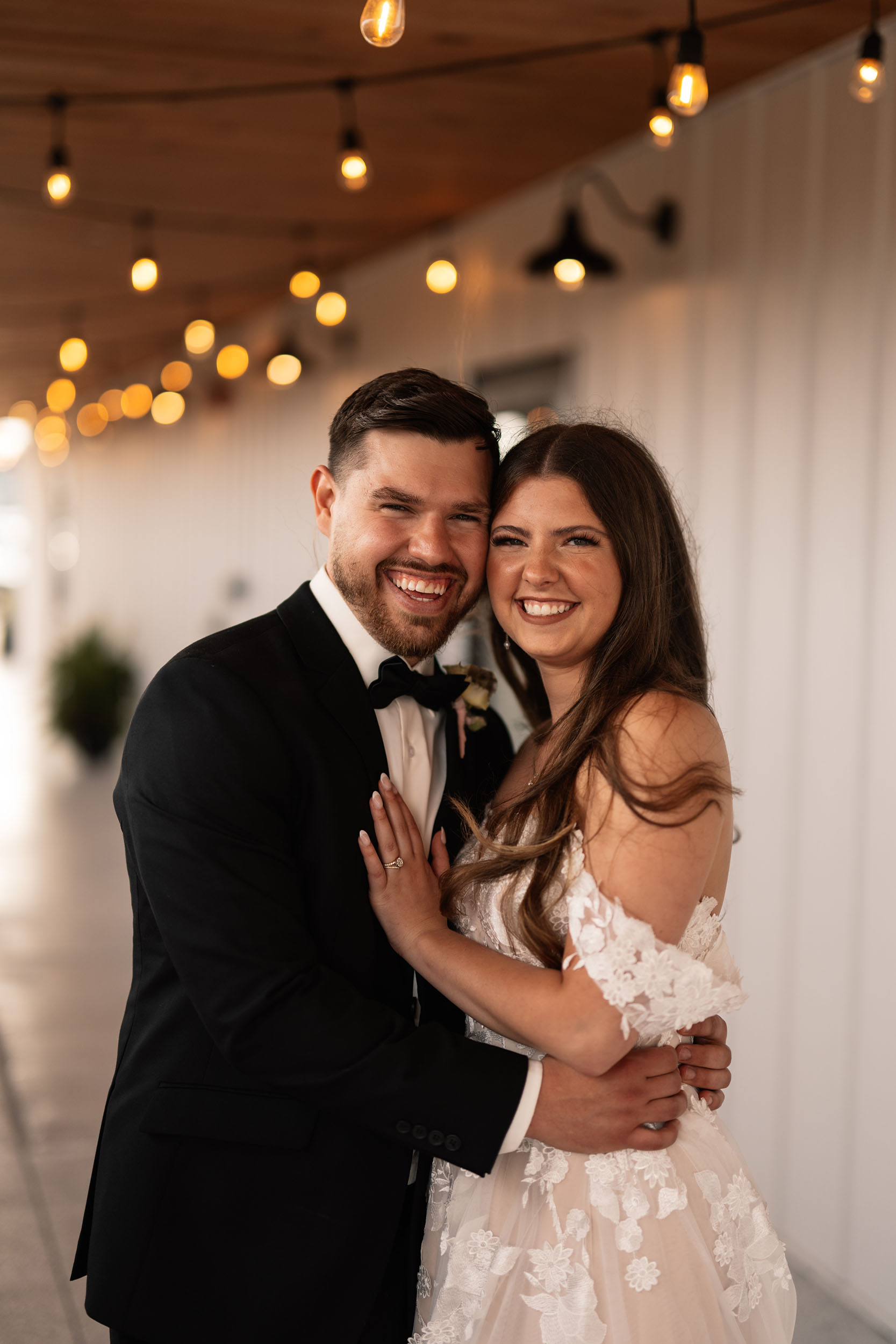 couple under twinkly light wedding arch brick wall olympic south side theater wedding venue cedar rapids