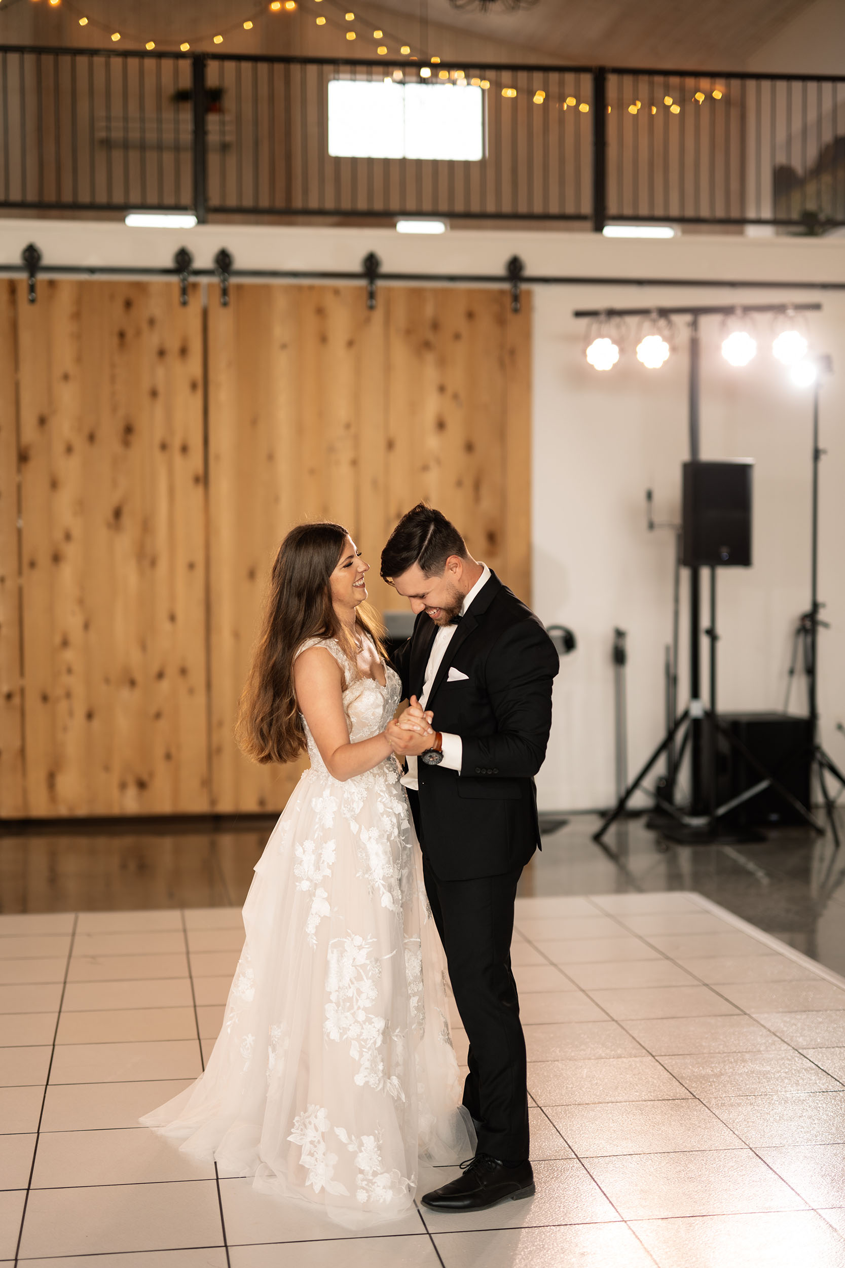 couple under twinkly light wedding arch brick wall olympic south side theater wedding venue cedar rapids