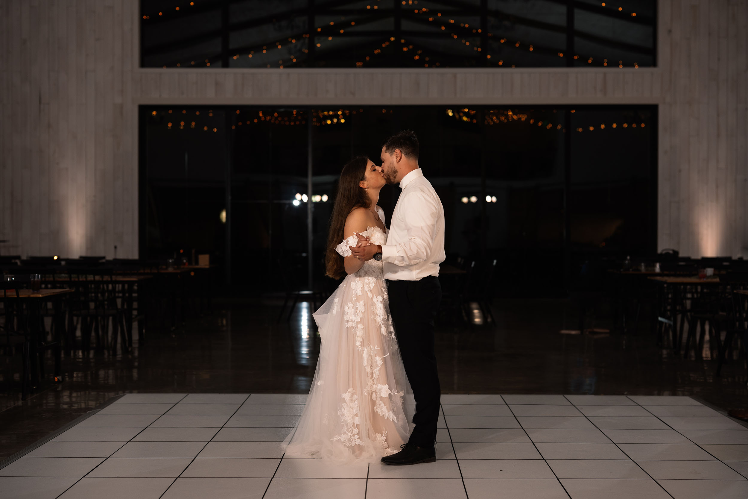 couple under twinkly light wedding arch brick wall olympic south side theater wedding venue cedar rapids