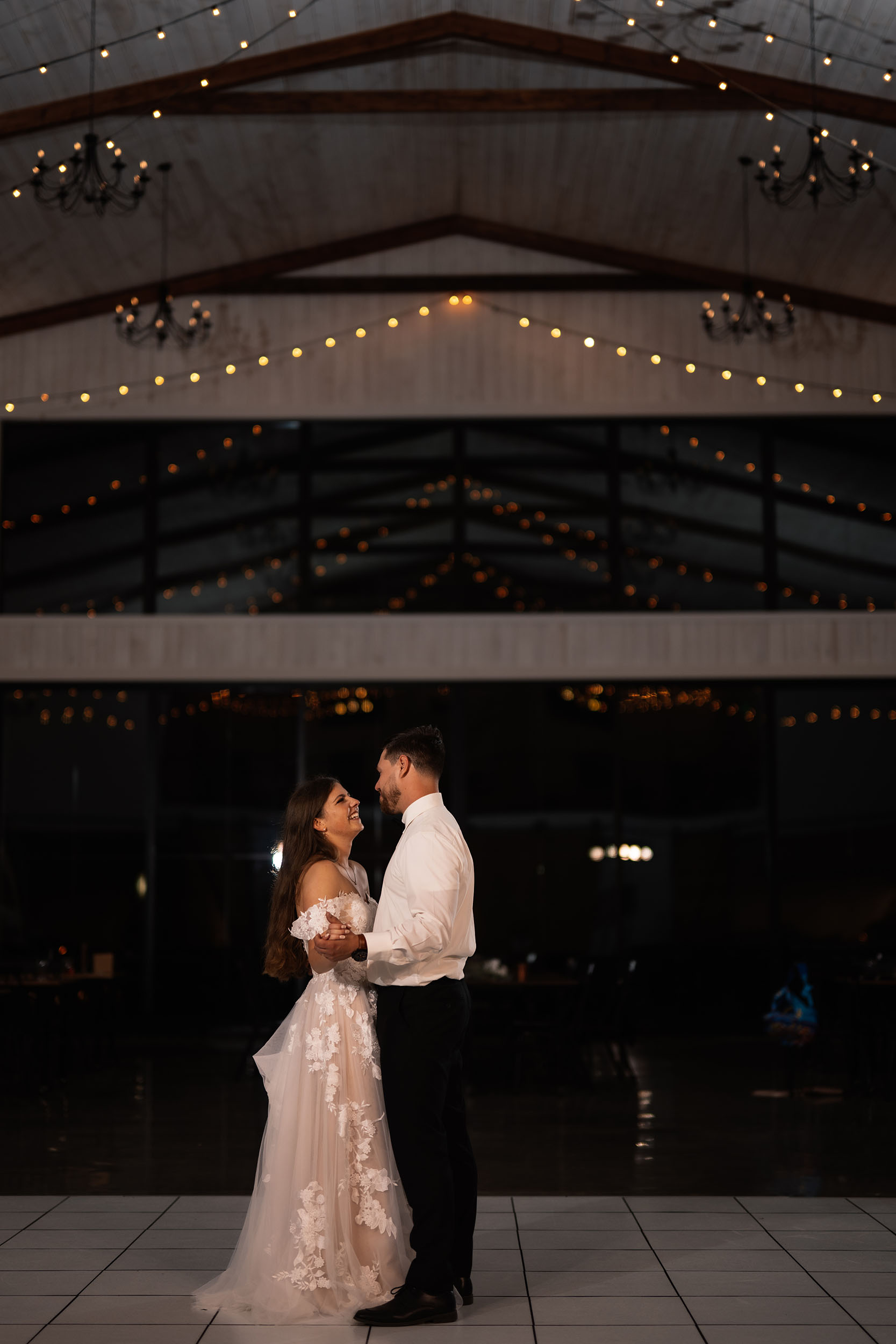 couple under twinkly light wedding arch brick wall olympic south side theater wedding venue cedar rapids