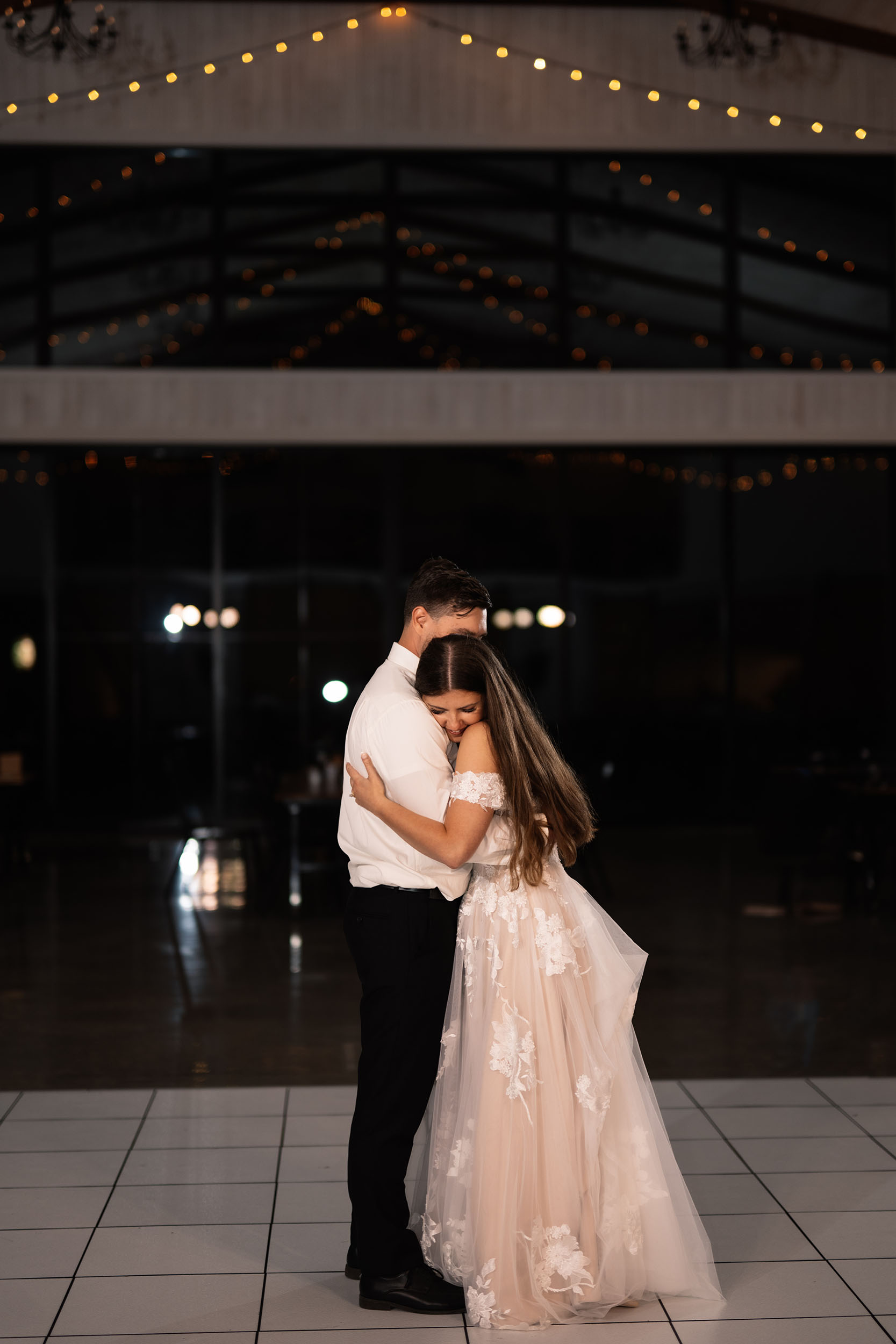 couple under twinkly light wedding arch brick wall olympic south side theater wedding venue cedar rapids