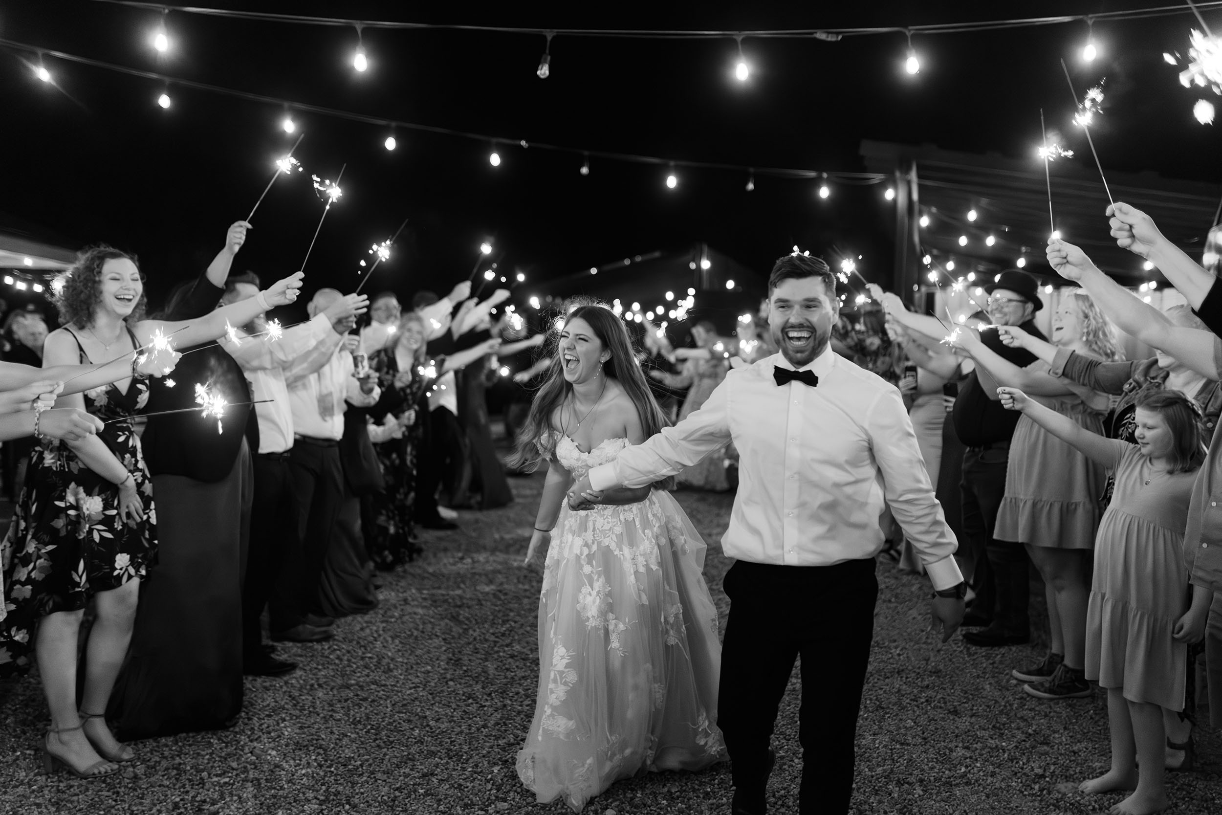 couple under twinkly light wedding arch brick wall olympic south side theater wedding venue cedar rapids